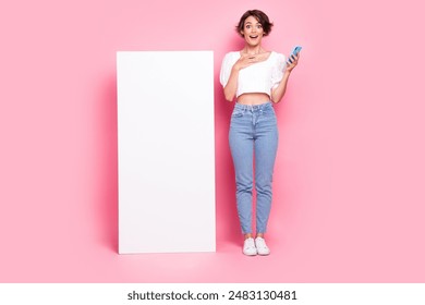Full length photo of sweet excited lady wear white blouse communicating modern gadget empty space isolated pink color background