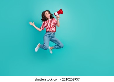 Full length photo of sweet funky lady wear striped t-shirt jumping high screaming toa empty space isolated turquoise color background