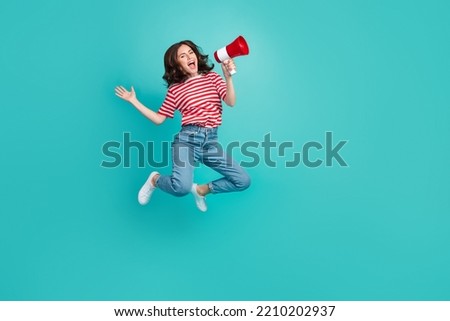 Full length photo of sweet funky lady wear striped t-shirt jumping high screaming toa empty space isolated turquoise color background