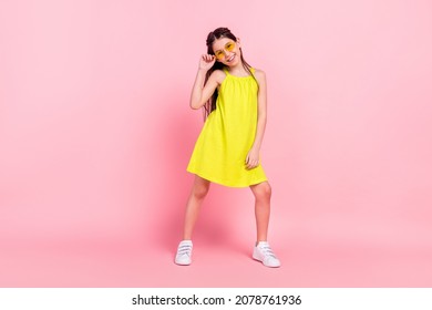 Full length photo of sweet funny schoolgirl dressed yellow outfit dark glasses dancing smiling isolated pink color background