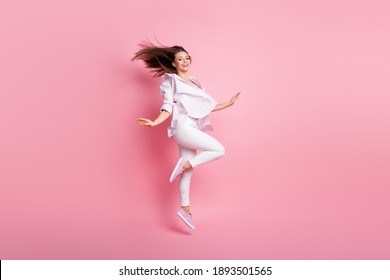 Full length photo of sweet pretty young lady wear casual white outfit jumping dancing hands arms sides isolated pink color background - Shutterstock ID 1893501565