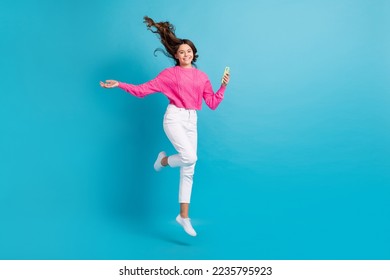 Full length photo of sweet pretty girl dressed knit pullover jumping high chatting apple samsung empty space isolated blue color background