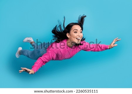 Full length photo of sweet shiny woman dressed pink sweater falling sky smiling isolated blue color background