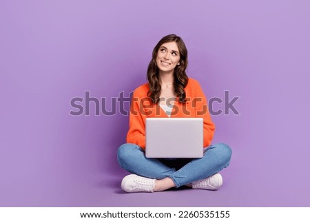 Full length photo of thoughtful dreamy lady wear orange cardigan looking empty typing sms device isolated violet color background