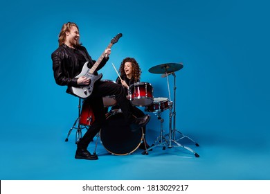 Full length photo two funky popular rock band perform new composition man play guitar woman drum drumstick enjoy punk night club tour wear leather jacket isolated bright color background - Powered by Shutterstock