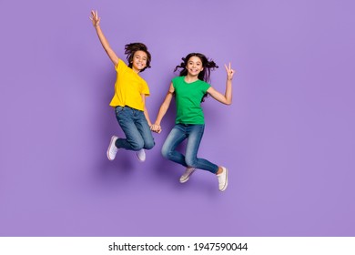 Full Length Photo Of Two Young Kids Happy Positive Smile Jump Up Girl Show Peace Cool V-sign Isolated Over Violet Color Background