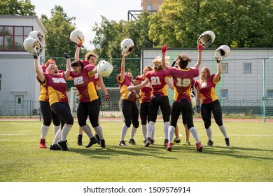 Full Length Photo Of Woman Rugby Team With Raised Hands Looking At Camera