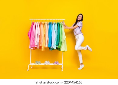 Full Length Photo Of Young Attractive Assistant Shop Expensive Clothes Sale Choose Isolated On Yellow Color Background