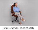 Full length photo of young business lady look empty space sit armchair crossed hands dressed stylish formalwear isolated on gray background