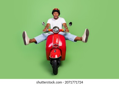 Full length photo of young cheerful afro man have fun yell ride retro bike isolated over green color background