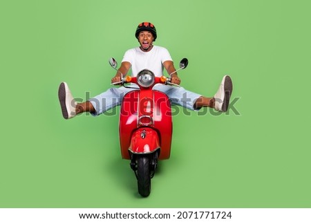 Full length photo of young cheerful afro man have fun yell ride retro bike isolated over green color background