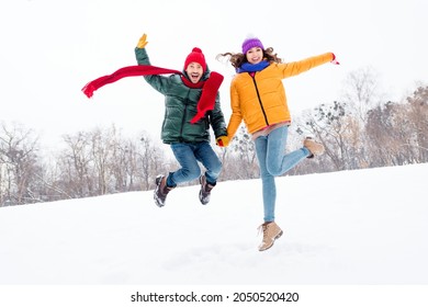 Full length photo of young excited couple happy positive smile have fun jump up enjoy weekend winter park