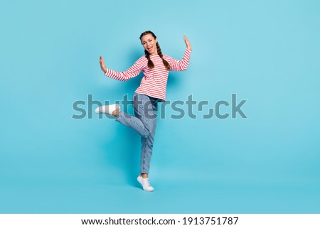 Full length photo of young excited girl happy positive smile have fun childish isolated over blue color background