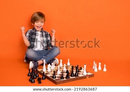 Full length photo of young excited boy rejoice victory fists hands awesome hooray isolated over orange color background