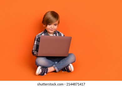 Full Length Photo Of Young Handsome Boy Type Email Homework Laptop Isolated Over Orange Color Background