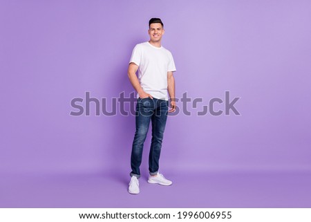 Full length photo of young handsome man happy positive smile hand in pocket confident isolated over violet color background