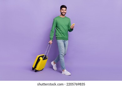 Full length photo of young hispanic arabian guy hold gadget tourist use roaming wear trendy green look isolated on violet color background