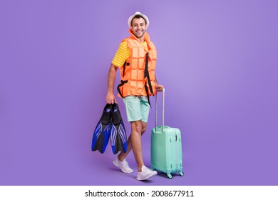 Full length photo of young man happy positive smile go walk trip abroad lifesaving vest flippers isolated over violet color background