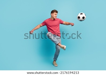 Full length photo of young man play soccer kick ball hobby sportive isolated over blue color background