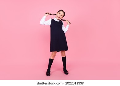 Full Length Photo Of Young School Girl Happy Positive Smile Hold Tails Have Fun Wear Uniform Isolated Over Pink Color Background
