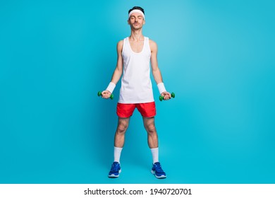 Full Length Photo Of Young Sportsman Enjoy Training Workout With Small Dumbells Isolated Over Blue Color Background