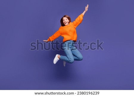 Full length photo of young teenage girl jumping trampoline looks like she flying with wings hands isolated on violet color background