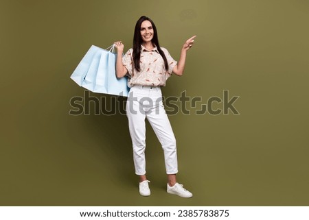 Full length photo of young woman promoter fashion boutique holding packages bags black friday discounts isolated on khaki color background