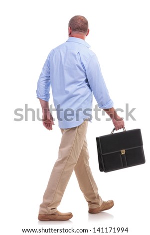 full length picture of a casual senior man walking away from the camera with a suitcase in his hand. isolated on white background