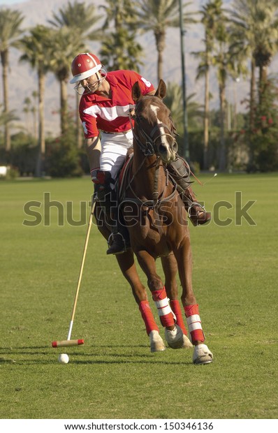 Full length of\
polo player swinging at\
ball