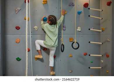 Full Length Portrait Of Active Black Child Climbing Wall On Home Sports Set, Copy Space