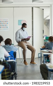 Full Length Portrait Of African-American Male Teacher Wearing Mask In School Classroom, Covid Safety Measures