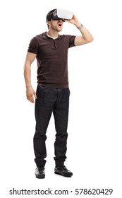 Full length portrait of an amazed guy using a virtual reality headset isolated on white background