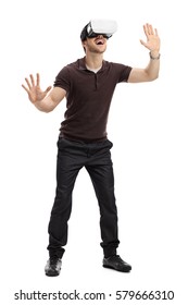 Full length portrait of an amazed man experiencing virtual reality through a headset isolated on white background