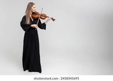 Full length portrait of attractive woman musician playing violin