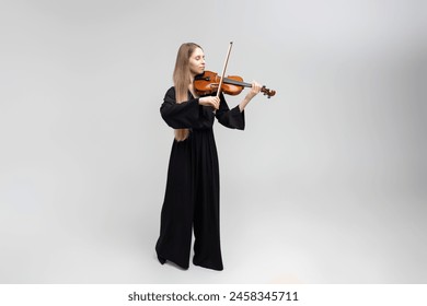 Full length portrait of attractive woman musician playing violin - Powered by Shutterstock