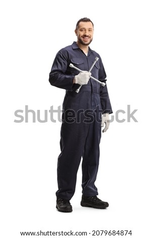 Full length portrait of an auto mechanic holding a lug wrench isolated on white background