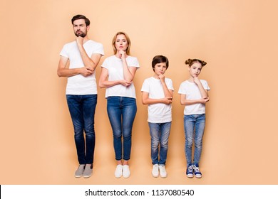 Full Length Portrait Of Beautiful  Family Bieng Confused, Bearded Father, Blonde Mother And Their Children Wearing Jeans And T-shirts, Standing Straight Showing Uncertain Gesture Their Hands To Chins