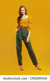 Full Length Portrait Of A Beautiful Modern Girl In Colorful Clothes Smiling At Camera. Fashion Shot.