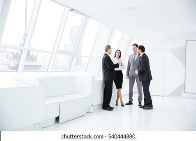Full length portrait of Business team stand near the window in conference room