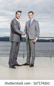 Full Length Portrait Of Businessmen Shaking Hands On Terrace