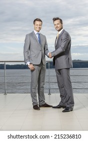 Full Length Portrait Of Businessmen Shaking Hands On Terrace