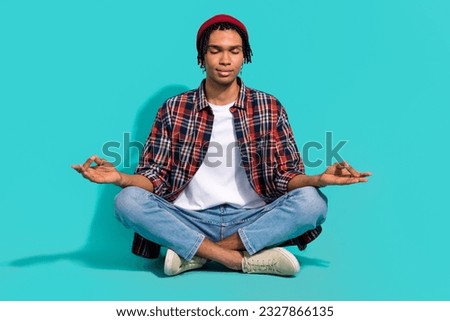 Full length portrait of calm nice person sitting floor crossed legs hands fingers meditate isolated on emerald color background