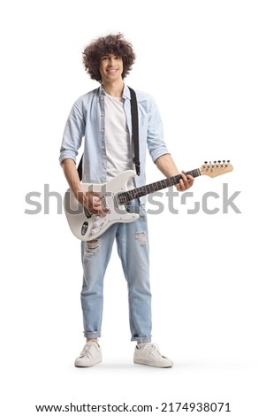 Full length portrait of a casual guy with curly hair playing a white electric guitar isolated on white background