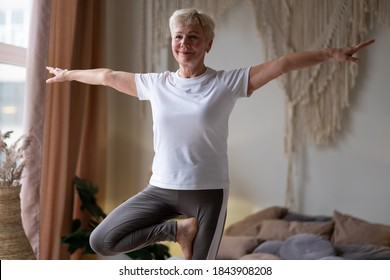 Full length portrait of caucasian senior woman in yoga pose vrikshasana, tree pose.