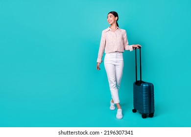 Full length portrait of cheerful nice person look empty space hold suitcase isolated on vibrant emerald color background - Powered by Shutterstock