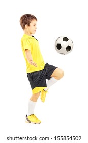 Full Length Portrait Of A Child In Sportswear Joggling With A Soccer Ball Isolated On White Background