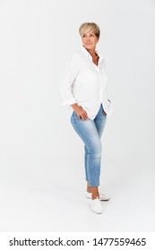 Full Length Portrait Closeup Of Mature Woman With Short Blond Hair Looking At Camera Isolated Over White Background In Studio