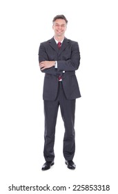 Full length portrait of confident businessman standing arms crossed against white background