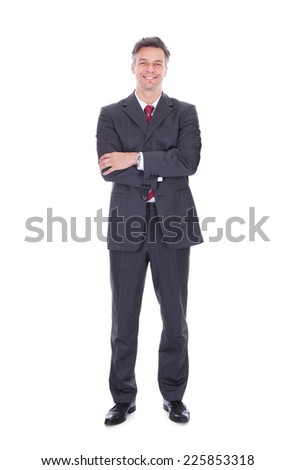 Full length portrait of confident businessman standing arms crossed against white background