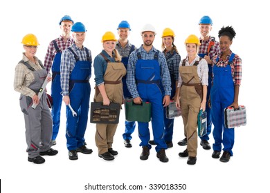 Full length portrait of confident carpenters carrying toolboxes against white background